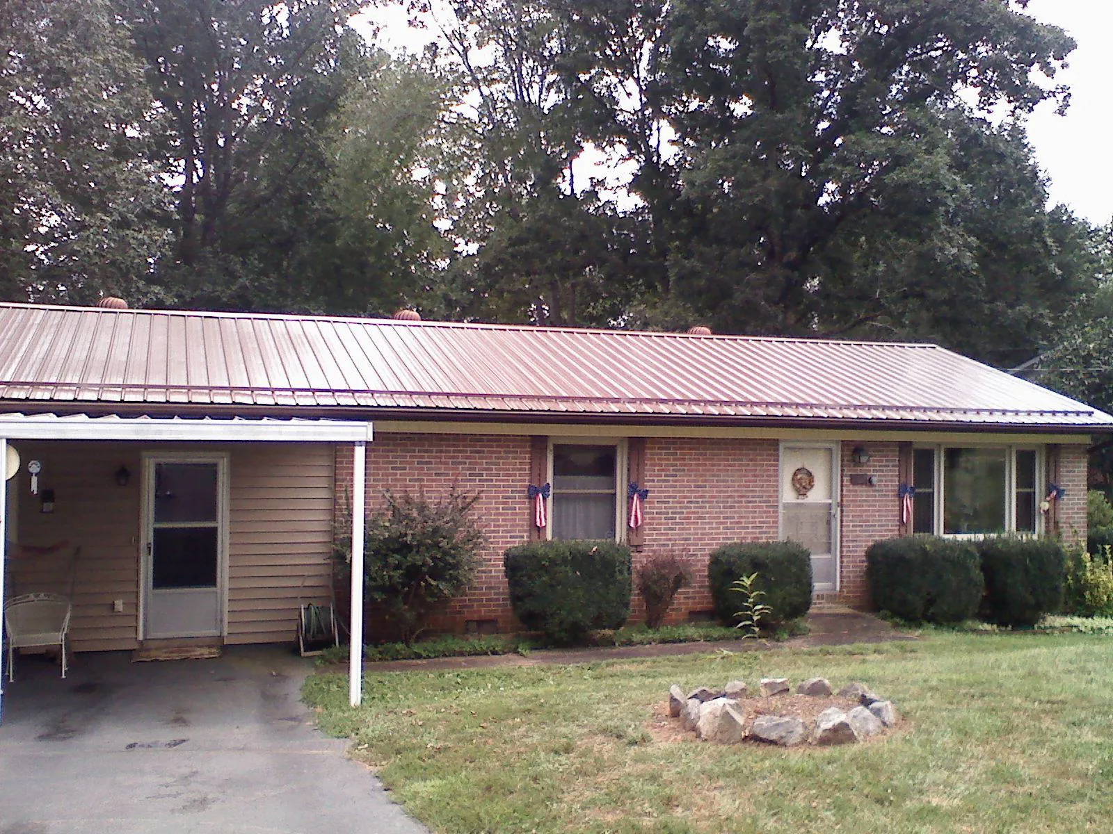 Bronze metal roof and carport on a brick ranch home — Roof Repair work by our crew in Craigsville